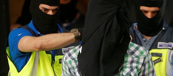 Police lead away a suspect from an apartment block during a raid in which they arrested a 32-year-old Moroccan they said was highly radicalised, in Madrid, Spain June 21, 2017 - Sputnik International