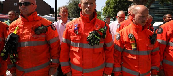 Members of the emergency services attend a minute's silence for the victims of the Grenfell Tower fire near the site of the blaze in North Kensington, London, Britain, June 19, 2017. - Sputnik International