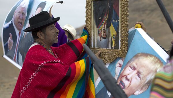 A shaman performs a ceremony holding a portrait of Venezuela's President Nicolas Maduro upside down, as another holds a poster of U.S. President Donald Trump, on Morro Solar in Lima, Peru, Monday, June 12, 2017 - Sputnik International