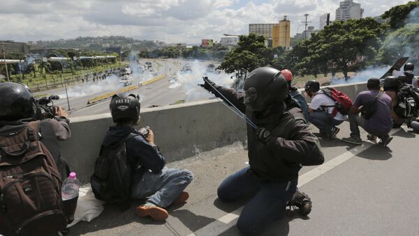 An anti-government demonstrator aims a slingshot during clashes with security forces along a highway in Caracas, Venezuela, Monday, June 19, 2017 - Sputnik International