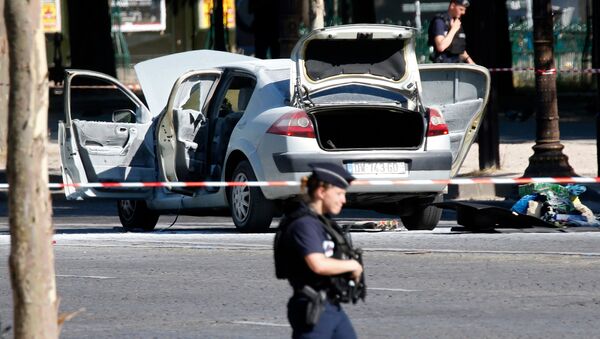 Police secure the area near a burned car at the scene of an incident in which it rammed a gendarmerie van on the Champs-Elysees Avenue in Paris, France, June 19, 2017 - Sputnik International