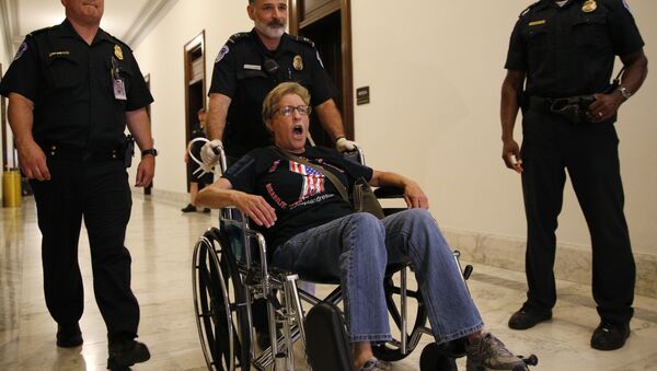 Police lead away protester at demonstration outside McConnell's office after Senate Republicans unveiled their healthcare bill in Washington - Sputnik International
