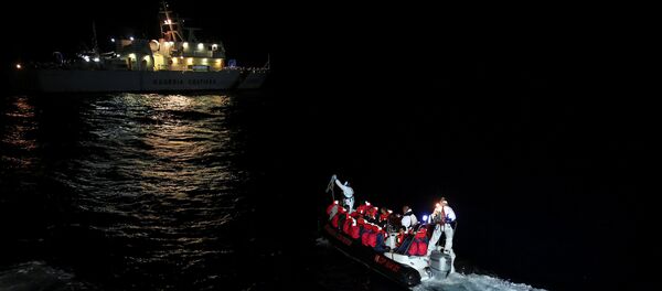 Fiorillo Italian Coast Guard vessel officers transfer migrants being rescued by Save the Children NGO crew from the ship Vos Hestia, in the Mediterranean sea off the Libyan coast, June 16, 2017 - Sputnik International