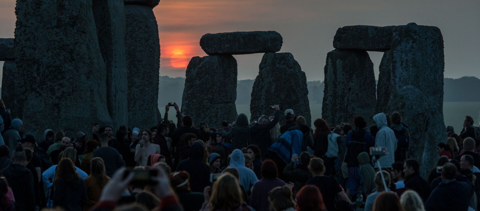 Revellers watch the sunrise as they celebrate the pagan festival of Summer Solstice at Stonehenge in Wiltshire, southern England on June 21, 2017 - Sputnik International, 1920, 15.03.2021