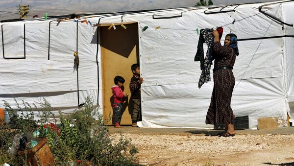 A Syrian refugee woman hangs laundry outside her tent at a Syrian refugee camp in the eastern city of Baalbek, Lebanon, Tuesday, June 20, 2017 - Sputnik International