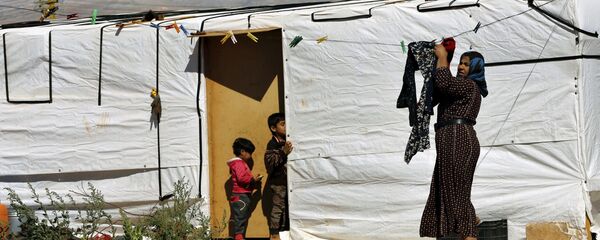A Syrian refugee woman hangs laundry outside her tent at a Syrian refugee camp in the eastern city of Baalbek, Lebanon, Tuesday, June 20, 2017 - Sputnik International