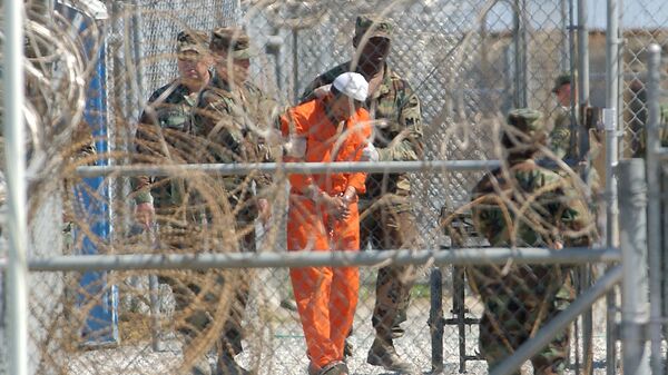 A detainee from Afghanistan is led by military police with his hands chained at Camp X-Ray at the U.S. Naval Base in Guantanamo Bay, Cuba, in this Feb. 2, 2002, file photo - Sputnik International