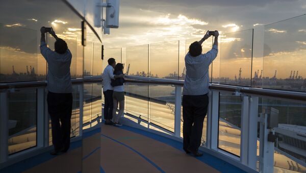 Passengers enjoy the sunset onboard Royal Caribbean's latest cruise ship the Ovation of the Seas ahead of its inaugural voyage at the International Cruise Terminal in northeastern China's Tianjin Municipality. (File) - Sputnik International