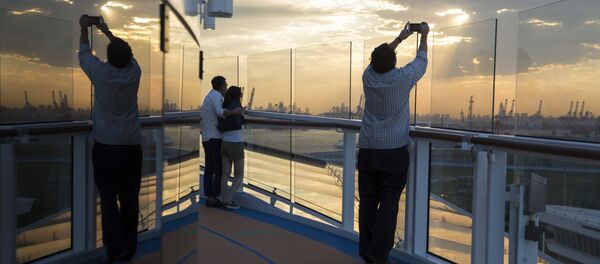 Passengers enjoy the sunset onboard Royal Caribbean's latest cruise ship the Ovation of the Seas ahead of its inaugural voyage at the International Cruise Terminal in northeastern China's Tianjin Municipality. (File) - Sputnik International