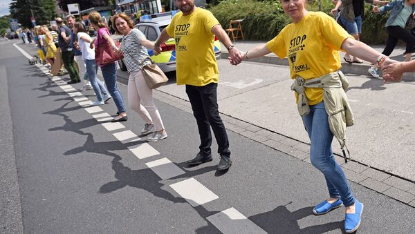 Participants of the anti-nuclear Chain Reaction demonstration build a human chain to protest against the operation of Belgium's Tihange 2 and the Netherland's Doel 3 nuclear power plants on June 25, 2017 in Aachen, western Germany, close to the border with Belgium and the Netherlands - Sputnik International