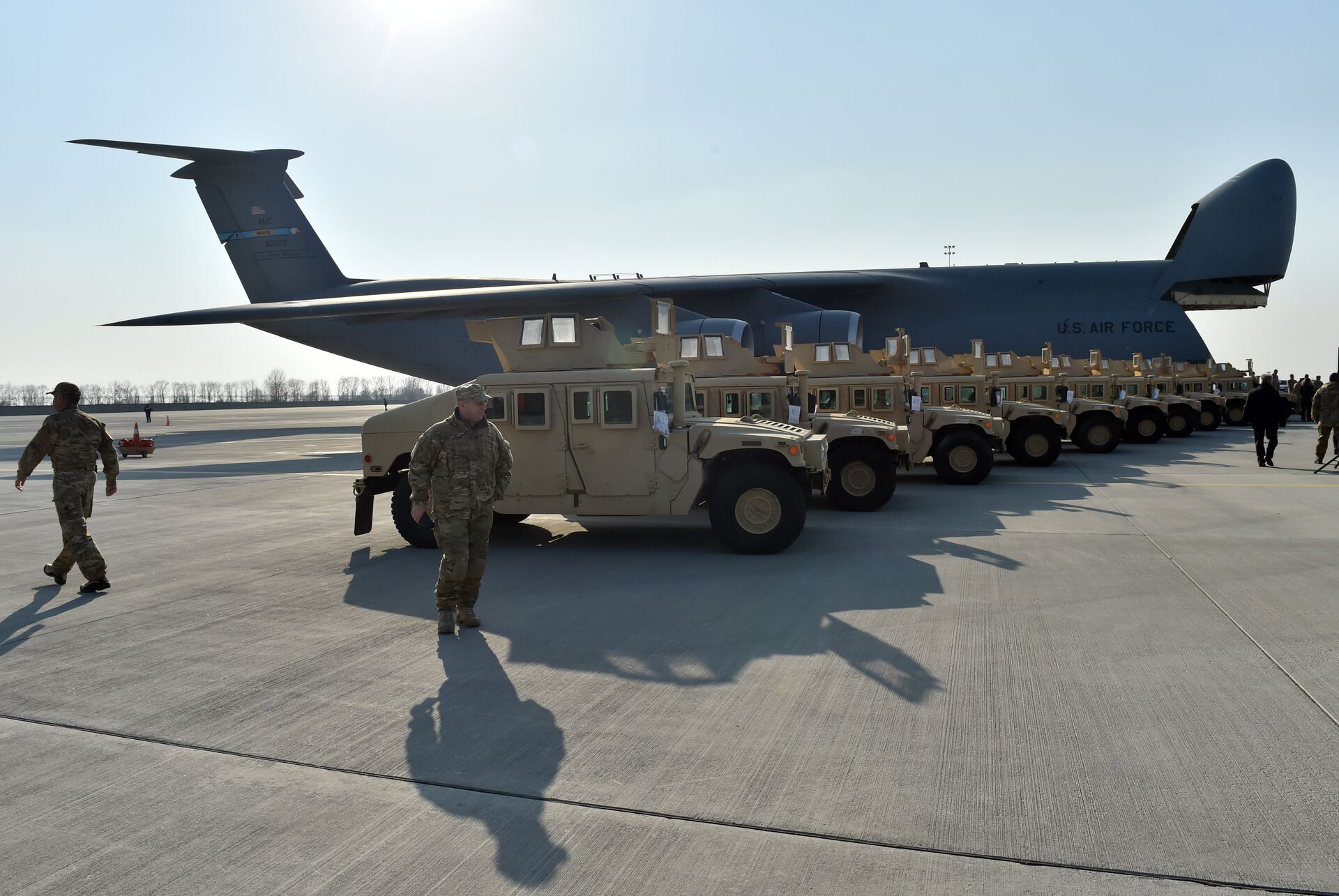 Ukrainian servicemen walk in front of armoured cars at Kiev airport on March 25, 2015 during a welcoming ceremony of the first US plane delivery of non-lethal aid, including 10 Humvee vehicles. - Sputnik International, 1920, 29.04.2022