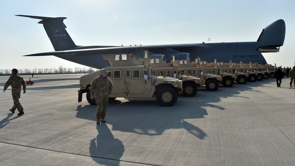 Ukrainian servicemen stroll in front of armored cars at Kiev airport on March 25, 2015 during a welcoming ceremony of the first US plane delivery of non-lethal aid, including 10 Humvee vehicles. - Sputnik International
