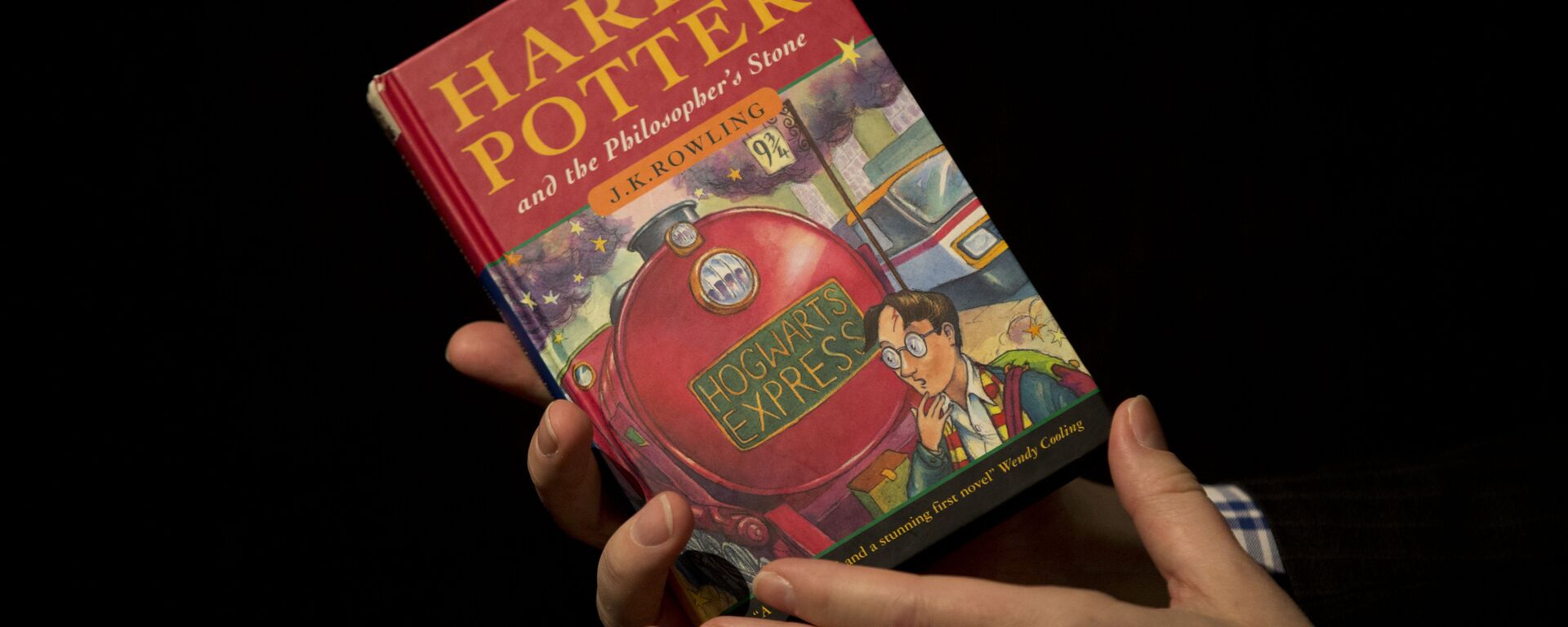 Sotheby's Director of the Department of Printed Books and Manuscripts Dr Philip Errington poses for photographers with a first edition copy of the first Harry Potter book Harry Potter and the Philosopher's Stone. - Sputnik International, 1920, 11.01.2023