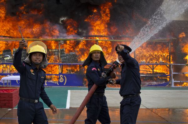 Myanmar fire fighters spray water while smokes and flames billow from burning drugs during a destruction ceremony of seized narcotic drugs in outskirts of Yangon, Myanmar, Monday, June 26, 2017. Myanmar fire fighters spray water while smokes and flames billow from burning drugs during a destruction ceremony of seized narcotic drugs in outskirts of Yangon, Myanmar, Monday, June 26, 2017. - Sputnik International