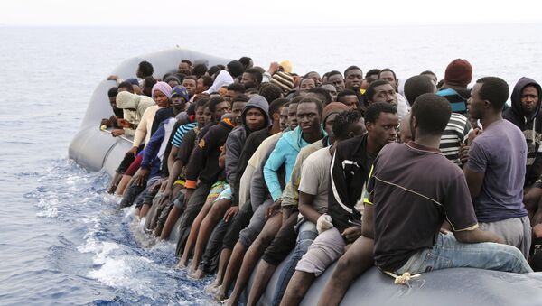 Migrants wait to be rescued from a sinking dingey off the Libyan coasal town of Zawiyah, east of the capital, on March 20, 2017, as they attempted to cross from the Mediterranean to Europe. - Sputnik International