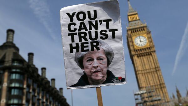 A placard showing a picture of Britain's Prime Minister Theresa May, saying You can't trust her is raised in front of the Elizabeth Tower, commonly referred to as Big Ben as protesters gather in Parliament Square after marching through central London on June 21, 2017. - Sputnik International