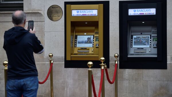 A man photographs a golden ATM, marking the location of the first 'hole in the wall,' which opened fifty years ago, in Enfield, Britain June 27, 2017. - Sputnik International