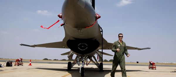 US Air Forces F-16 demonstration team pilot, Ryan Worrell from Iowa, walks past the F-16, a fighter aircraft, on display on the fourth day of the Aero India 2013 at Yelahanka air base in Bangalore, India, Saturday, Feb. 9, 2013. - Sputnik International