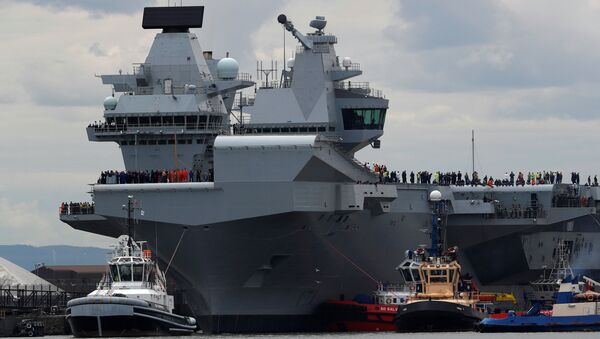 The British aircraft carrier HMS Queen Elizabeth is pulled from its berth by tugs before its maiden voyage, in Rosyth, Scotland, Britain June 26, 2017. - Sputnik International