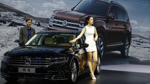 A female worker poses near cars from SAIC Volkswagen during the Auto Shanghai 2017 show at the National Exhibition and Convention Center in Shanghai, China, Thursday, April 20, 2017 - Sputnik International
