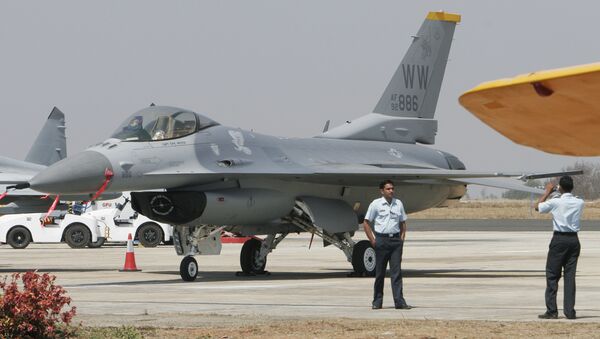 An Indian Air Force official poses for photographs with U.S. fighter aircraft F-16 parked at Yelahanka air base (File) - Sputnik International