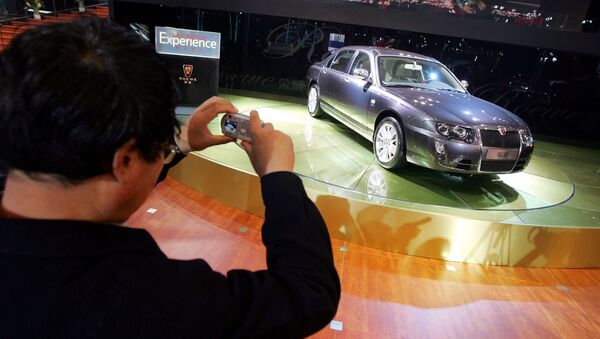 A visitor takes photos of the Roewe 750, made by Chinese auto maker SAIC Motor Corp., at the Beijing Auto Show (File) - Sputnik International