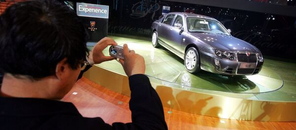 A visitor takes photos of the Roewe 750, made by Chinese auto maker SAIC Motor Corp., at the Beijing Auto Show (File) - Sputnik International