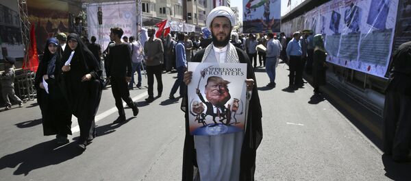 A clergyman holds a poster showing caricatures of U.S. President Donald Trump, center, Israeli Prime Minister Benjamin Netanyahu, left, and Saudi Arabia's King Salman in an annual pro-Palestinian rally marking Al-Quds (Jerusalem) Day in Tehran, Iran, Friday, June 23, 2017 - Sputnik International