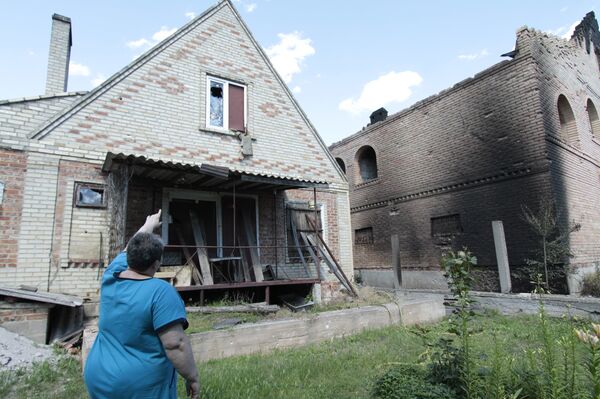 A local woman near a house damaged by artillery shelling in Aleksandrovka village in the Donetsk Region. - Sputnik International