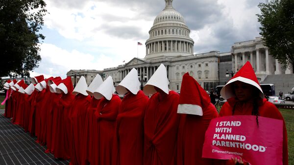 Women dressed as handmaids from the novel, film and television series The Handmaid's Tale demonstrate against cuts for Planned Parenthood in the Republican Senate healthcare bill at the U.S. Capitol in Washington, U.S., June 27, 2017 - Sputnik International
