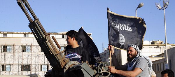 Libyan men hold Al-Qaeda flags while sitting next to an anti-aircraft artillery weapon (File) - Sputnik International
