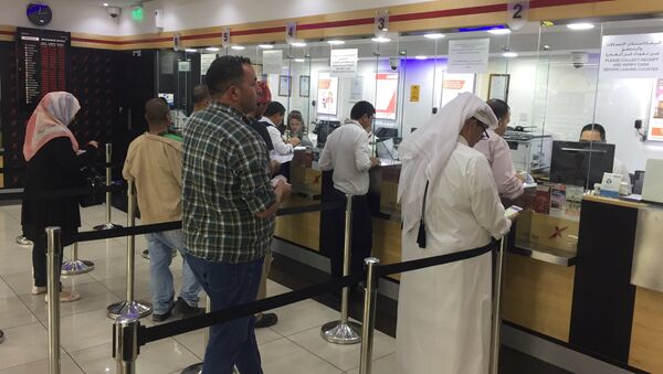 People exchange money from an exchange house in Doha, Qatar, June 11, 2017 - Sputnik International