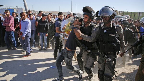Israeli border police detain a Palestinian youth as crowds make their way through the Israeli Qalandia checkpoint, in the occupied West Bank between Ramallah and Jerusalem, to attend Friday prayer of the holy fasting month of Ramadan in Jerusalem's al-Aqsa mosque, on June 16, 2017 - Sputnik International