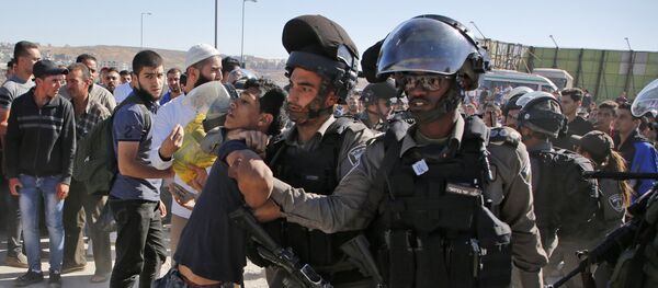 Israeli border police detain a Palestinian youth as crowds make their way through the Israeli Qalandia checkpoint, in the occupied West Bank between Ramallah and Jerusalem, to attend Friday prayer of the holy fasting month of Ramadan in Jerusalem's al-Aqsa mosque, on June 16, 2017 Israeli border police detain a Palestinian youth as crowds make their way through the Israeli Qalandia checkpoint, in the occupied West Bank between Ramallah and Jerusalem, to attend Friday prayer of the holy fasting month of Ramadan in Jerusalem's al-Aqsa mosque, on June 16, 2017 - Sputnik International