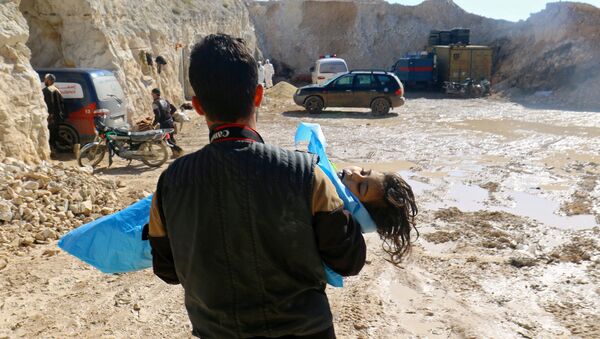 A man carries the body of a dead child, after what rescue workers described as a suspected gas attack in the town of Khan Sheikhoun in rebel-held Idlib, Syria April 4, 2017 - Sputnik International