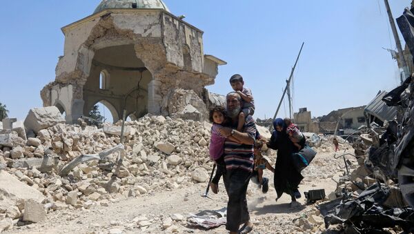 Displaced Iraqi civilians walk past the ruined Grand al-Nuri Mosque after fleeing from the Old City in Mosul, Iraq, June 30, 2017 - Sputnik International