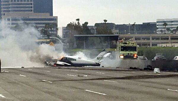 Flame and smoke erupt from a twin-engine prop jet after it crashed on Interstate 405, just short of the runway at John Wayne Orange County Airport, in Costa Mesa, Calif., Friday, June 30, 2017. - Sputnik International