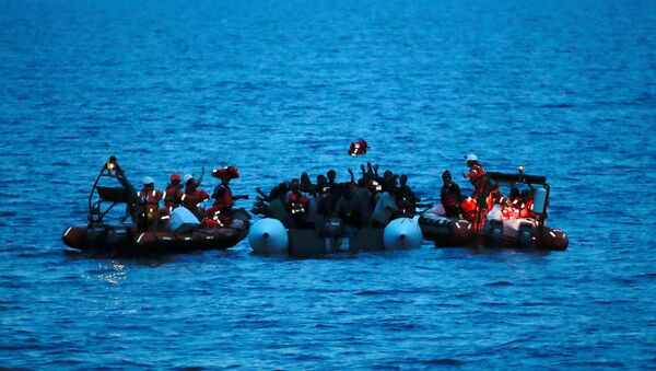 Migrants on a dinghy are rescued by Save the Children NGO crew from the ship Vos Hestia in the Mediterranean sea off Libya coast, June 17, 2017 - Sputnik International