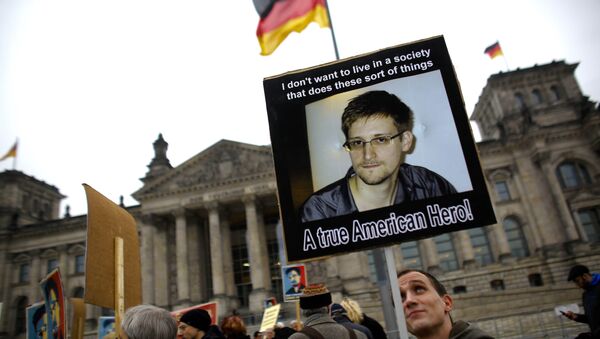 Protesters hold posters of former National Security Agency member Edward Snowden in front of the German parliament building, the Reichstag, prior to a special meeting of the parliament on US-German relationships, in Berlin, Monday, Nov. 18, 2013 - Sputnik International