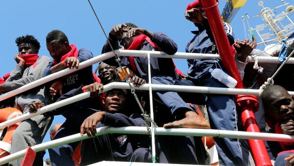 Migrants waits to disembark from the Vos Hestia ship as they arrives in the Crotone harbour, Italy, after being rescued by  Save the Children crew in the Mediterranean sea off the Libya coast, June 21, 2017 - Sputnik International