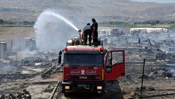 Civil defence members put out fire at a camp for Syrian refugees near the town of Qab Elias, in Lebanon's Bekaa Valley - Sputnik International