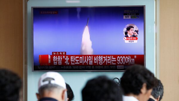 People watch a TV broadcast of a news report on North Korea's ballistic missile test, at a railway station in Seoul, South Korea, July 4, 2017. - Sputnik International