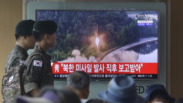 Army soldiers walk by a TV news program showing a file image of a missile being test-launched by North Korea at the Seoul Railway Station in Seoul, South Korea, Tuesday, July 4, 2017. - Sputnik International
