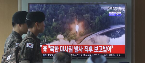 Army soldiers walk by a TV news program showing a file image of a missile being test-launched by North Korea at the Seoul Railway Station in Seoul, South Korea, Tuesday, July 4, 2017. - Sputnik International