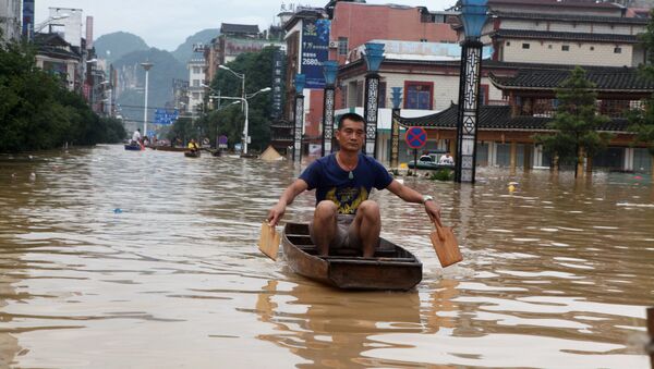 A man makes his way with a wooden boat through a flooded area in Liuzhou, Guangxi province, China July 2, 2017. - Sputnik International