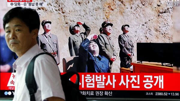 A man walks past a TV broadcasting still photographs released by North Korea's state-run television KRT of North Korea's Hwasong-14 missile, a new intercontinental ballistic missile, which they said was successfully tested, at a railway station in Seoul, South Korea, July 4, 2017. - Sputnik International