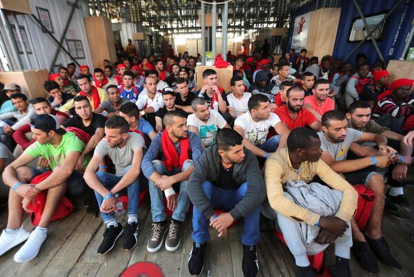 Migrants wait to disembark from the Vos Hestia ship as they arrive at the Crotone harbour, after being rescued by a Save the Children crew in the Mediterranean sea off the Libya coast, in Crotone, Italy June 21, 2017. Migrants wait to disembark from the Vos Hestia ship as they arrive at the Crotone harbour, after being rescued by a Save the Children crew in the Mediterranean sea off the Libya coast, in Crotone, Italy June 21, 2017. - Sputnik International