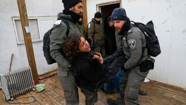 Israeli policemen remove a pro-settlement activist from a house during an operation by Israeli forces to evict settlers from the illegal outpost of Amona in the occupied West Bank February 1, 2017. - Sputnik International