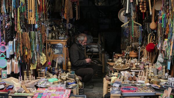 A Syrian man sits inside his handicraft shop in the Syrian capital, Damascus - Sputnik International