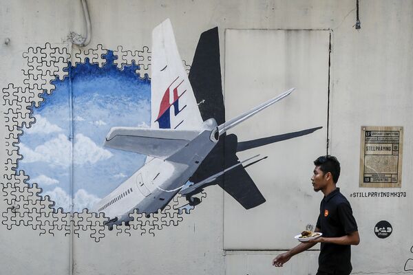 In this Tuesday, Feb. 23, 2016, file photo, a waiter walks past a mural of flight MH370 in Shah Alam outside Kuala Lumpur, Malaysia. In this Tuesday, Feb. 23, 2016, file photo, a waiter walks past a mural of flight MH370 in Shah Alam outside Kuala Lumpur, Malaysia. - Sputnik International